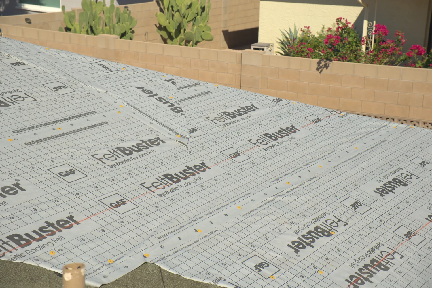 A roof deck fully covered in GAF FeltBuster underlayment before shingles